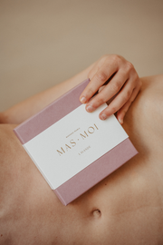 A person holds a Masmoi box labeled 'Lavande' against their bare torso, highlighting the Lavender Scent Massage Oil pearls inside. 